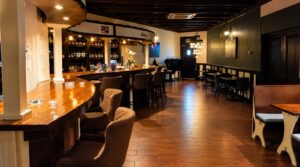 Curved wooden bar and bar stools at The High Lounge cannabis social club in Los Montesinos