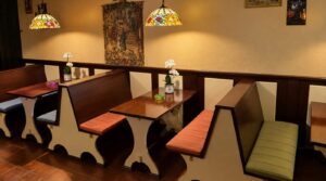 Wooden booth seating and Tiffany lamps at The High Lounge cannabis social club in Los Montesinos